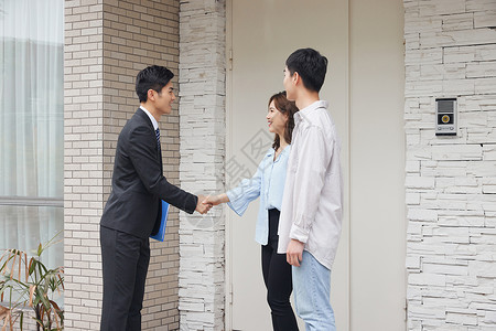 房地产中介向夫妻销售房产握手洽谈高清图片素材
