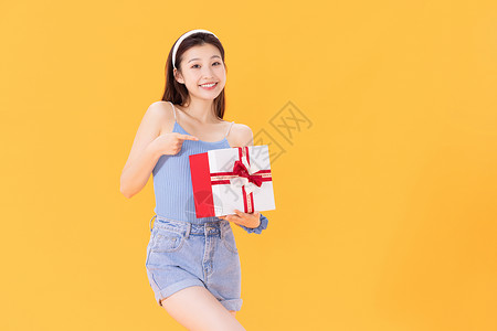 圣诞节促销素材抱着礼物盒的年轻女性背景