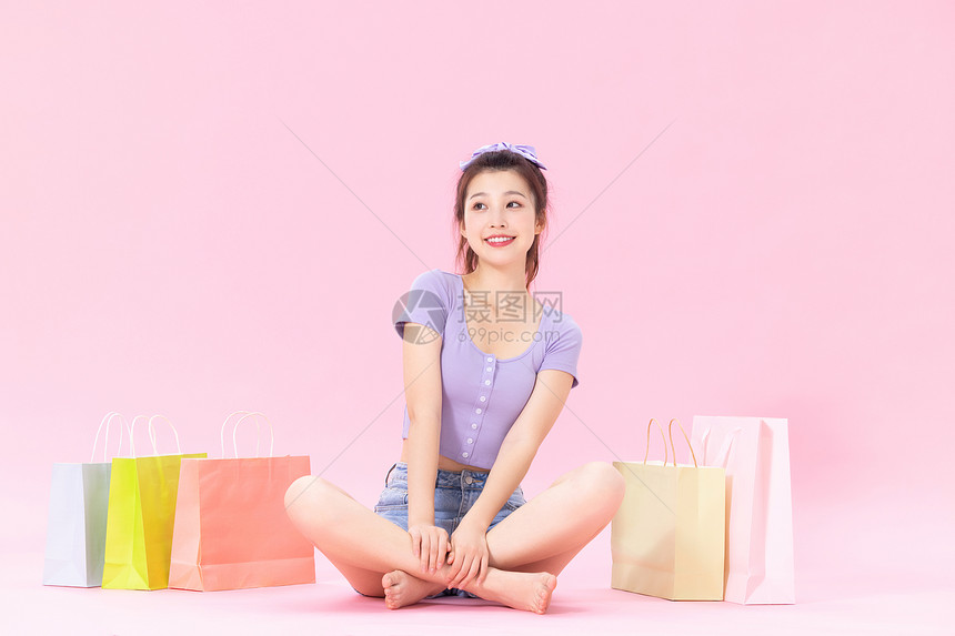 坐在购物袋旁的美女图片
