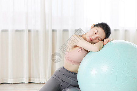 瑜伽美女趴在瑜伽球上休息图片