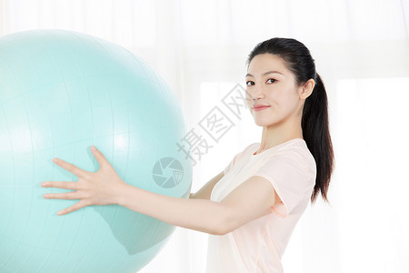 瑜伽美女使用瑜伽球运动背景图片