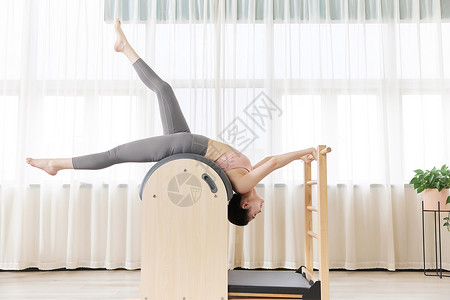 瑜伽锻炼女孩瑜伽女孩普拉提梯桶练习背景