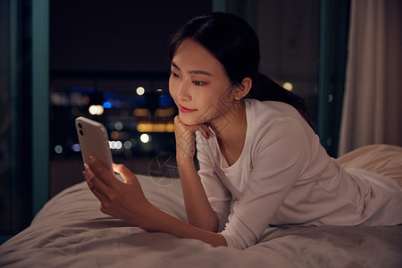 卡通人物躺着玩手机青年女性深夜睡前躺床上玩手机背景