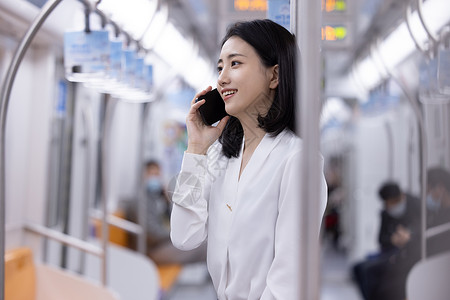 地铁上打电话的女性背景图片