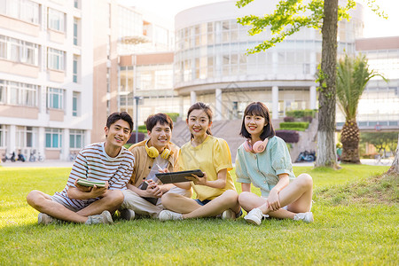 年轻大学生坐在草坪上形象高清图片