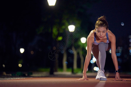 夜跑跑道公园健身女性起跑动作背景