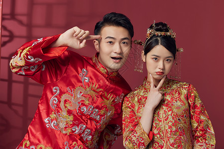 穿中式古装结婚礼服的俏皮新婚夫妻背景图片