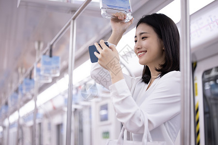 乘坐地铁下班的职场女性使用手机图片