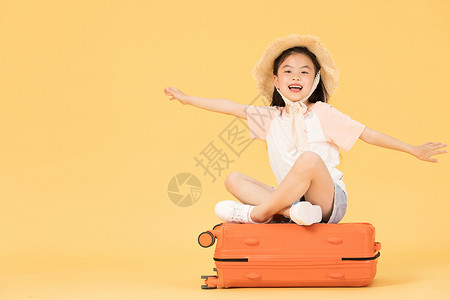 机票和行李箱坐在行李箱上拿着机票和护照的小女孩背景