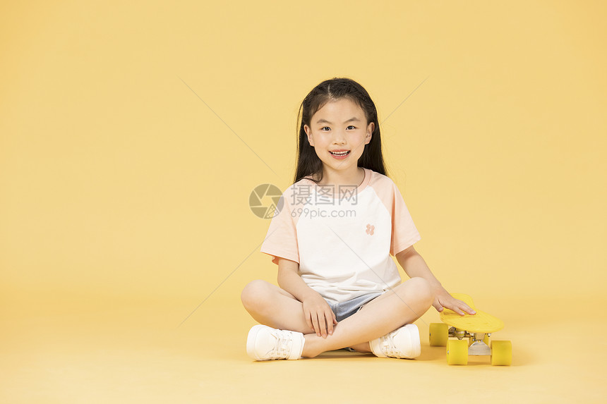 坐在滑板上的小女孩图片