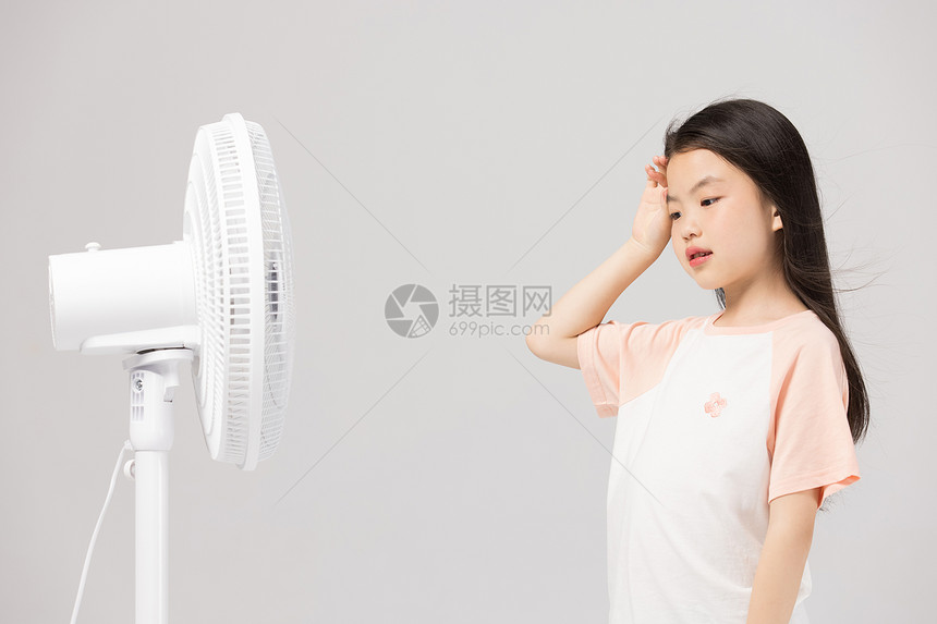 夏天吹风扇擦汗的小女孩图片