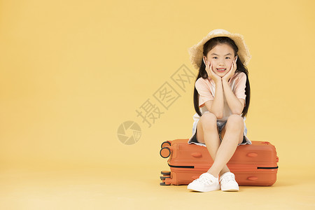 坐在行李箱上的小女孩背景图片