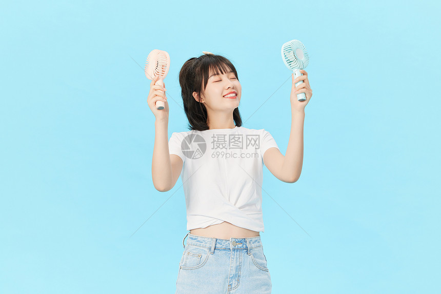 夏日清凉美女享受风扇的风图片