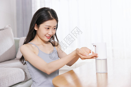 夏日清凉美女居家使用自动洗手液机高清图片