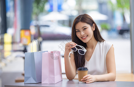 美女逛街购物喝咖啡拿墨镜图片