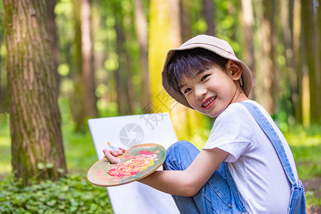 在树林里画画的小男孩图片