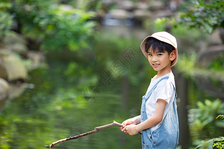 夏日钓鱼男孩在户外小溪边钓鱼的小男孩背景