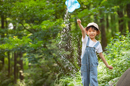 暑期玩水小男孩在森林溪边玩水背景