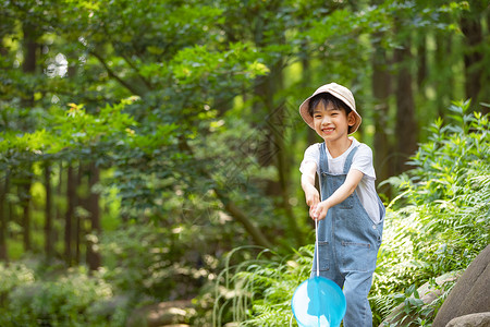 小男孩在森林溪边玩水背景图片