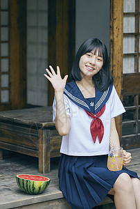 坐在西瓜上消暑的女孩夏日可爱制服女孩背景