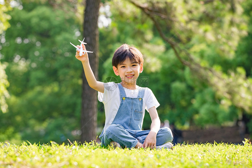 举起飞机模型的小男孩图片