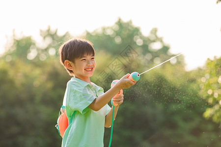 快乐暑假生活户外拿着水枪玩耍的小男孩背景