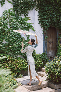 中国风庭院旗袍美女撑油纸伞跳舞背景图片