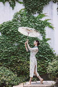 中国风庭院旗袍美女撑油纸伞跳舞背景图片