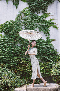 中国风庭院旗袍美女撑油纸伞跳舞背景图片
