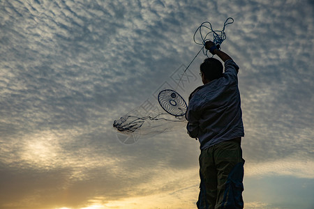飞钓者夕阳下捕捞的渔民背景