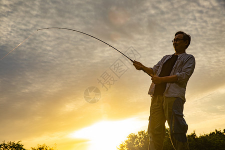 飞钓者夕阳时分钓鱼的男性背景