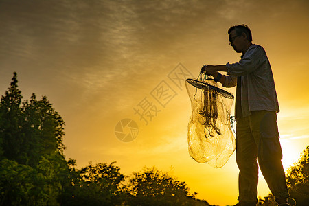 网钓夕阳下捕捞的渔民背景
