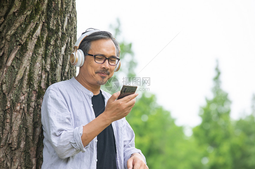 中年男性户外看手机节目图片