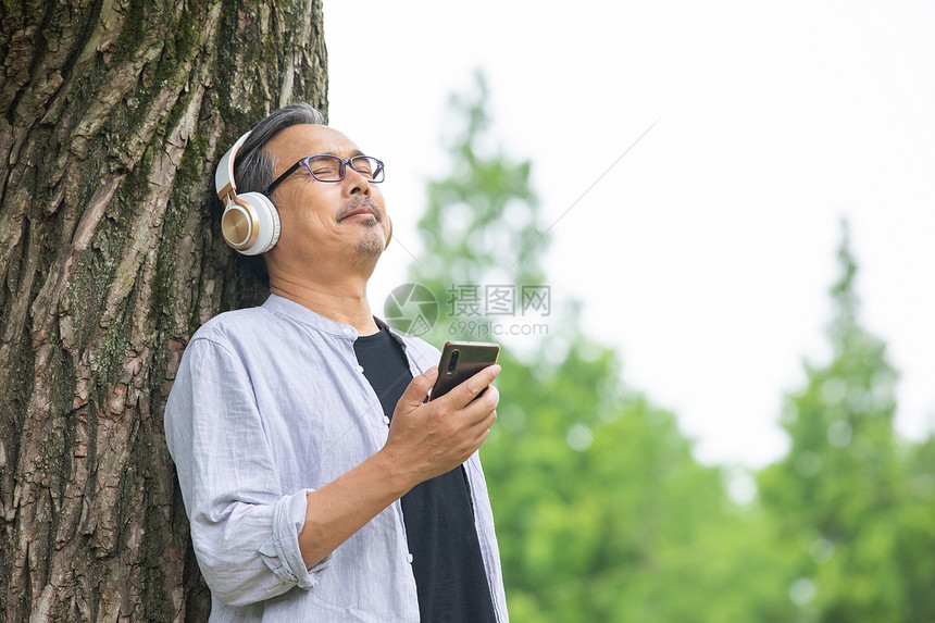戴着耳机听音乐的中年男性图片