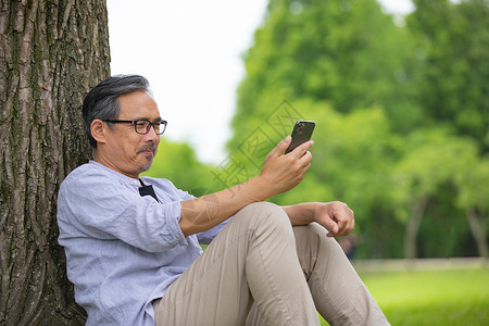 户外使用手机的中年男性图片