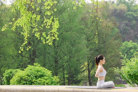 女性在公园里做瑜伽锻炼背景图片