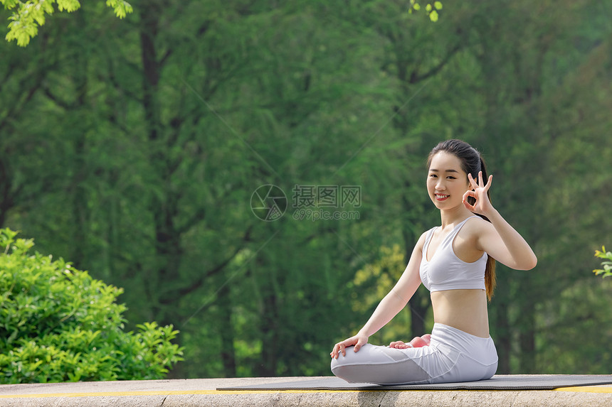女性在公园里做瑜伽比ok手势图片