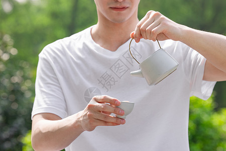 男性在户外倒茶特写图片