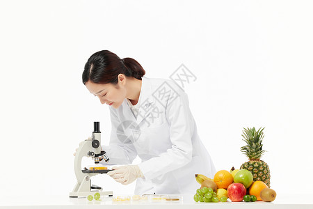 女性营养师观察食品样本营养师用显微镜观察食品样本背景
