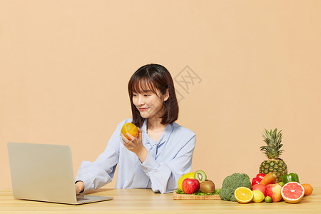 科学吃水果青年女性看电脑吃水果背景