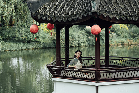 中国亭子湖边凉亭里的旗袍美女背景