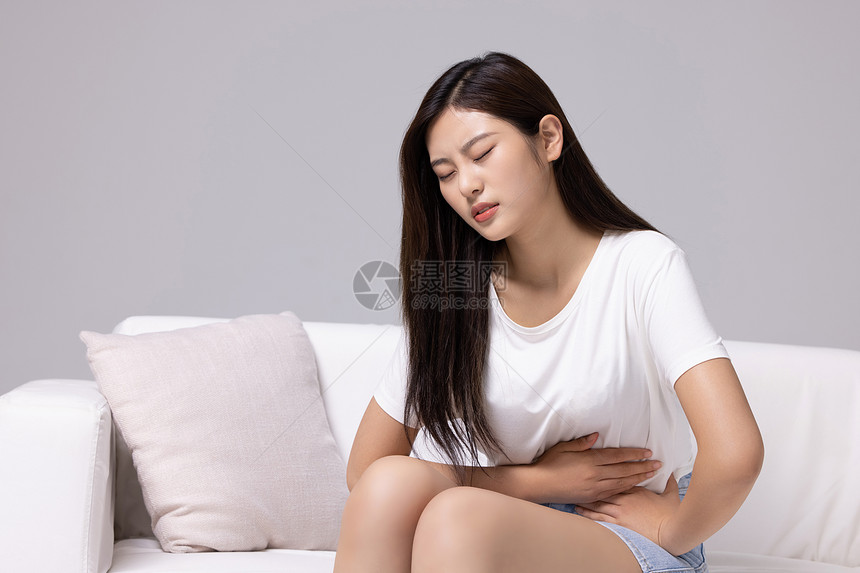 腹部疼痛的居家女性图片