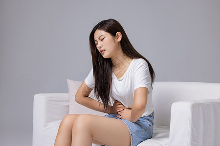 腹部疼痛的年轻女性背景图片