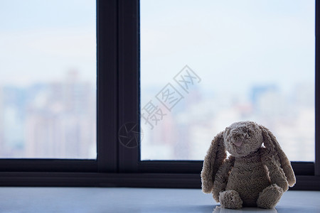 窗台上孤独的玩偶静物图片