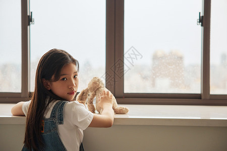 趴在窗前表情孤独的小女孩图片