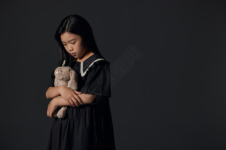 抱着玩偶伤心的小女孩图片