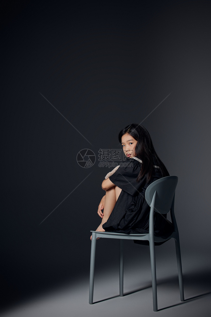 坐在椅子上的孤独小女孩图片