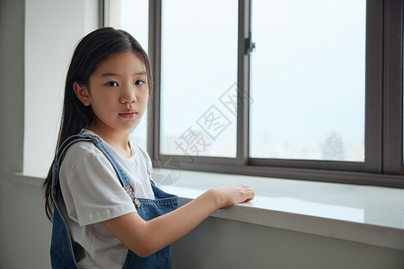 趴在窗前表情难过的小女孩背景