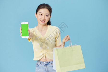 年轻时尚美女展示手机购物背景图片