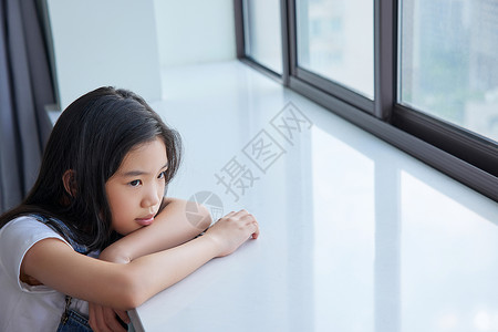 孤单的留守儿童趴在窗边图片